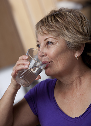 Mujer bebiendo un vaso de agua.